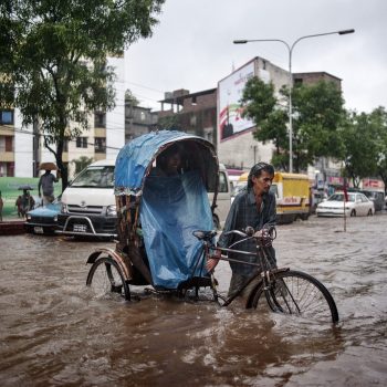 A rickshaw driver tries to cross a completely flooded road.
Dhaka, Bangladesh. 09/08/2011
A rickshaw driver is forced to get off and stop, pedaling to cross a flooded road in an attempt to bring the customer to his destination. The lack of urban planning and the fast urbanization of the city is literally allowing parts of the city to sink and during the rainy season, many areas of Dhaka are often flooded. For generations, Dhaka has been a magnet for those escaping rural poverty, but now climate change is accelerating the race to the capital. Between 300,000 to 400,000 people move to Dhaka every year, according to the World Bank, driven by a mix of economic and environmental pressures. 
(The image is a spontaneous scene of everyday city life and was created without affecting the scene and without giving any indication to the photographed subject.)